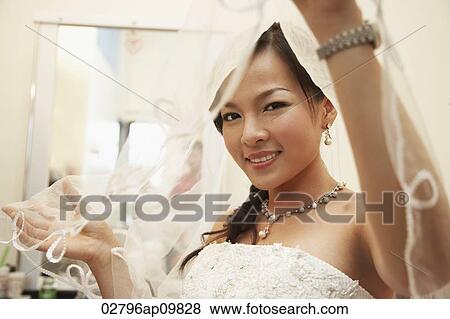 Stock Photo - bride looking under a veil. Fotosearch
