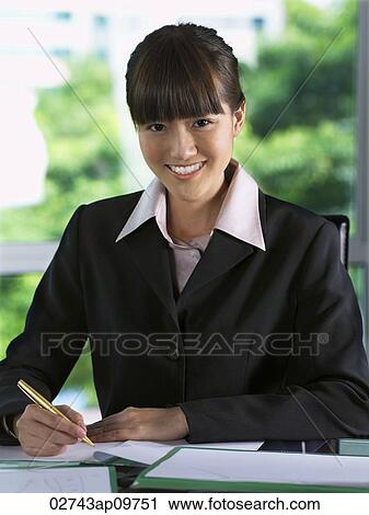 "business woman sitting at desk, smiling" View Large Photo Image Stock Image - "business woman sitting at desk, smiling". Fotosearch