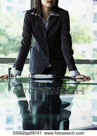 Stock Image - Business woman with hands on table. Fotosearch