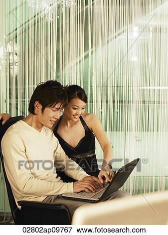 Stock Photo - couple looking at computer. Fotosearch