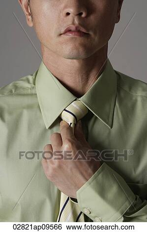 crop portrait of man tightening tie View Large Photo Image Stock Photograph - crop portrait of man tightening tie. Fotosearch