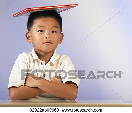 little boy balancing a book on his head View Large Photo Image Stock Photo - little boy balancing a book on his head. Fotosearch