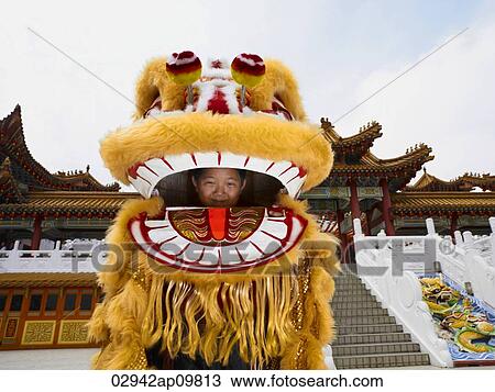 Stock Image - little boy inside of Chinese lion dance costume. Fotosearch