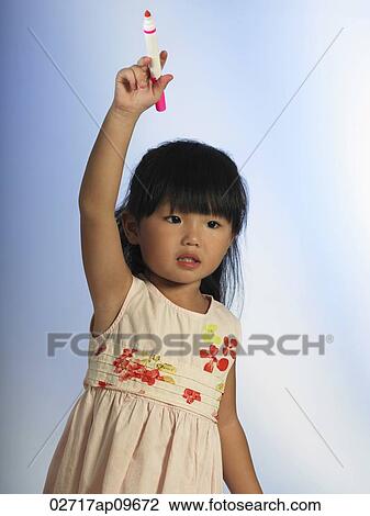 little girl holding a marker high up in her hand View Large Photo Image Stock Image - little girl holding a marker high up in her hand. Fotosearch