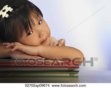 little girl resting her head on a stack of books View Large Photo Image Picture - little girl resting her head on a stack of books. Fotosearch