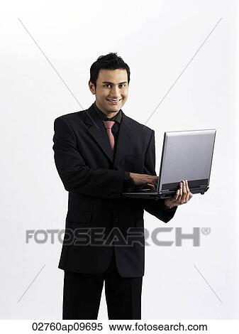 man holding a laptop on one arm View Large Photo Image Stock Photography - man holding a laptop on one arm. Fotosearch