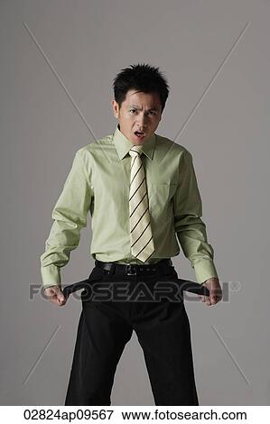 Stock Photo - man looking at pockets with empty pockets. Fotosearch