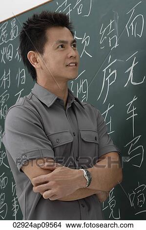 man standing in front of Chinese characters written on chalk board View Large Photo Image Picture - man standing in front of Chinese characters written on chalk board. Fotosearch