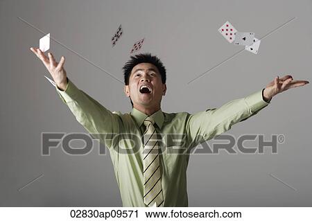 man throwing cards up into the air View Large Photo Image Stock Image - man throwing cards up into the air. Fotosearch