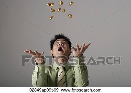 man throwing gold into the air View Large Photo Image Stock Photo - man throwing gold into the air. Fotosearch