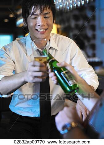 Stock Image - man toasting a drink with friend. Fotosearch
