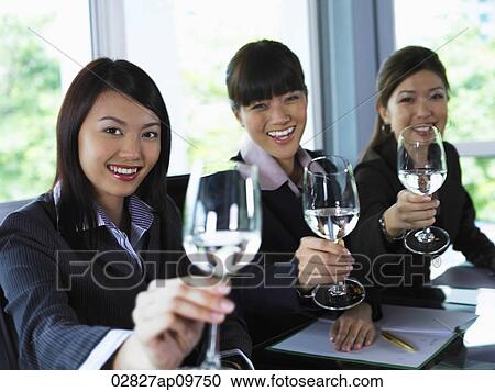Stock Image - Three woman toasting the camera. Fotosearch
