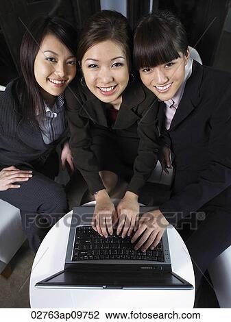 Three woman working on laptop View Large Photo Image Stock Image - Three woman working on laptop. Fotosearch