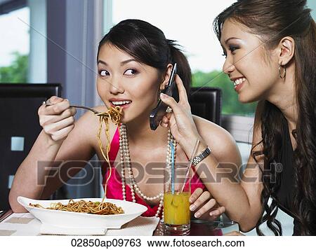 Stock Image - two women having lunch together. Fotosearch