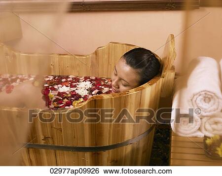 woman relaxing in wooden tub with flowers View Large Photo Image Stock Photograph - woman relaxing in wooden tub with flowers. Fotosearch