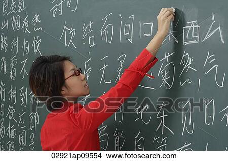 Picture - woman writing chinese characters on chalk board. Fotosearch
