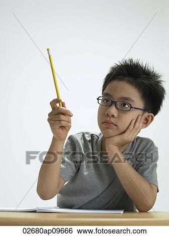 Stock Photograph - young boy holding up a pencil. Fotosearch