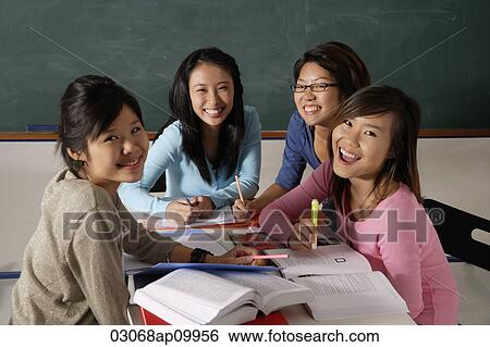 Four young women studying together and laughing. View Large Photo Image Stock Photograph - Four young women studying together and laughing.. Fotosearch