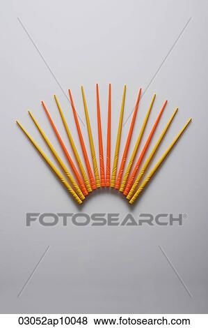 Stock Photo - Orange and yellow chopsticks in the shape of a fan.. Fotosearch