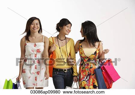 Stock Image - Three women carrying shopping bags.. Fotosearch