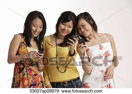 Stock Photo - Three women looking at hand phones.. Fotosearch