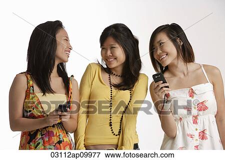 Three young women with handphones View Large Photo Image Stock Photo - Three young women with handphones. Fotosearch