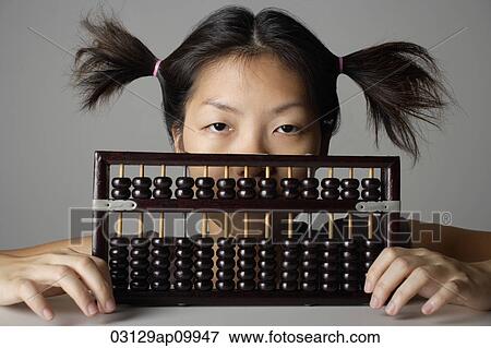 Young woman peering behind abacus. View Large Photo Image Stock Photo - Young woman peering behind abacus.. Fotosearch