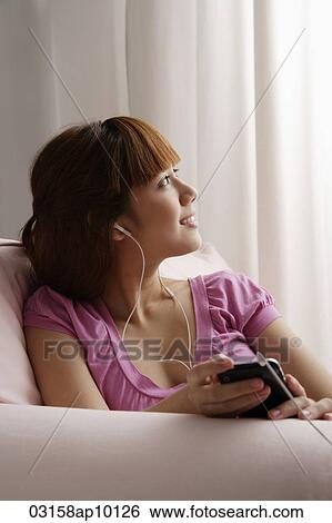 Asian girl listening to music and looking out the window View Large Photo Image Stock Photograph - Asian girl listening to music and looking out the window. Fotosearch
