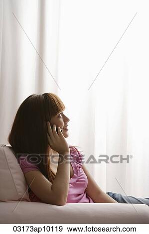 Asian girl looking out window while talking on phone View Large Photo Image Stock Photo - Asian girl looking out window while talking on phone. Fotosearch