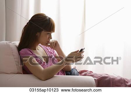 Asian girl reading a text message View Large Photo Image Stock Image - Asian girl reading a text message. Fotosearch
