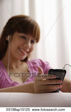 Asian girl reading listening to music View Large Photo Image Stock Photography - Asian girl reading listening to music. Fotosearch