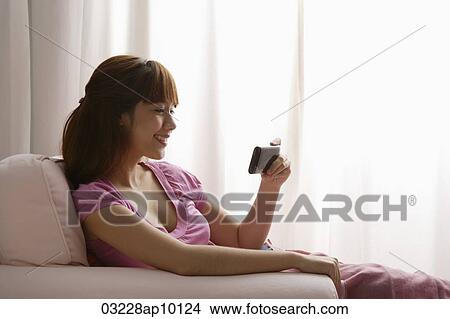 Asian girl reading text message View Large Photo Image Picture - Asian girl reading text message. Fotosearch
