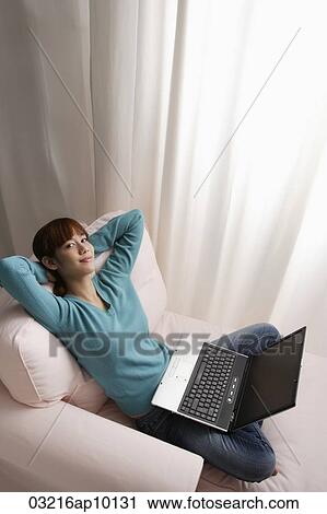 Asian girl relaxing at home with laptop View Large Photo Image Stock Image - Asian girl relaxing at home with laptop. Fotosearch