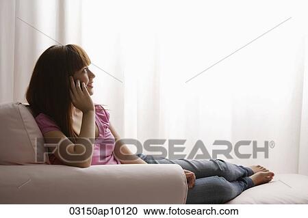 Asian girl talking on phone while looking out the window View Large Photo Image Stock Image - Asian girl talking on phone while looking out the window. Fotosearch