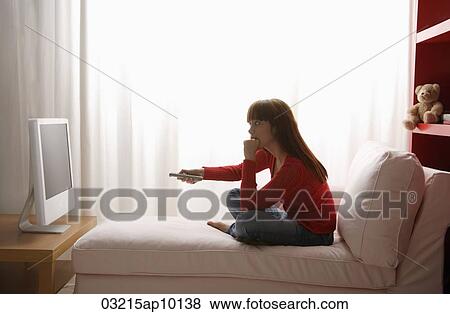 Stock Photo - Asian girl watching TV in her bedroom. Fotosearch