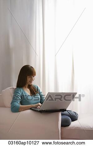 Asian girl with laptop at home View Large Photo Image Stock Photo - Asian girl with laptop at home. Fotosearch