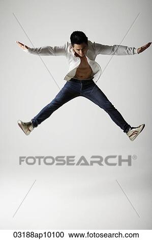 Stock Image - Man jumping and spreading arms and legs. Fotosearch