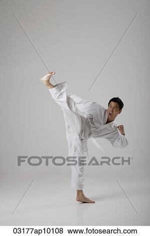 Stock Photo - Man kicking high in the air, martial arts. Fotosearch
