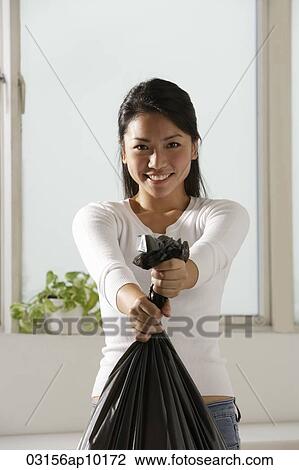Young Asian woman holding trash bags View Large Photo Image Stock Image - Young Asian woman holding trash bags. Fotosearch