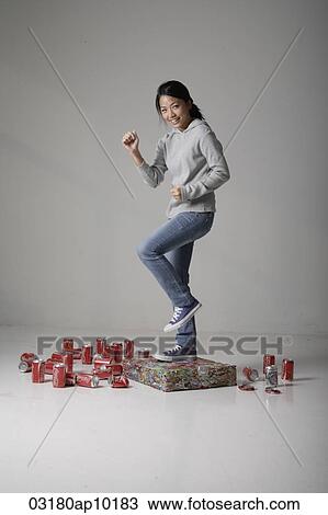 Young Asian woman jumping on cans View Large Photo Image Stock Image - Young Asian woman jumping on cans. Fotosearch