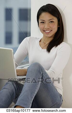 Young Asian woman working on laptop View Large Photo Image Stock Photo - Young Asian woman working on laptop. Fotosearch