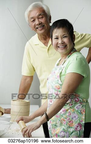 Chinese couple cooking together and smiling View Large Photo Image Stock Photograph - Chinese couple cooking together and smiling. Fotosearch