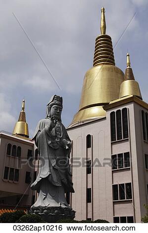 Golden spires and Buddhist Statue View Large Photo Image Stock Photograph - Golden spires and Buddhist Statue. Fotosearch