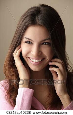 head shot of young woman with hands on her face View Large Photo Image Stock Photo - head shot of young woman with hands on her face. Fotosearch