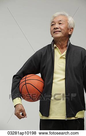 Mature Chinese man holding a basketball View Large Photo Image Stock Photo - Mature Chinese man holding a basketball. Fotosearch