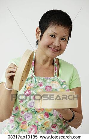 Mature Chinese woman holding bamboo steamer View Large Photo Image Stock Photography - Mature Chinese woman holding bamboo steamer. Fotosearch