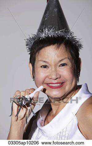 Mature Chinese woman wearing a party hat and smiling View Large Photo Image Stock Photograph - Mature Chinese woman wearing a party hat and smiling. Fotosearch