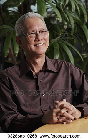 mature man sitting in front of plant smiling View Large Photo Image Stock Photo - mature man sitting in front of plant smiling. Fotosearch