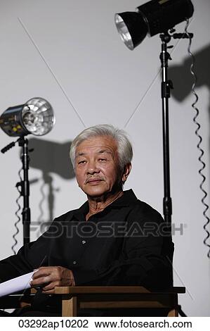 Mature man sitting on film set View Large Photo Image Stock Image - Mature man sitting on film set. Fotosearch