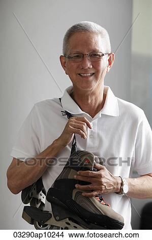 mature man with white hair holding roller blades View Large Photo Image Picture - mature man with white hair holding roller blades. Fotosearch